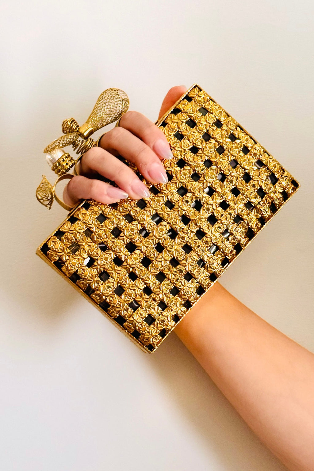 Handcrafted golden clutch with embossed metallic finish and snap closure