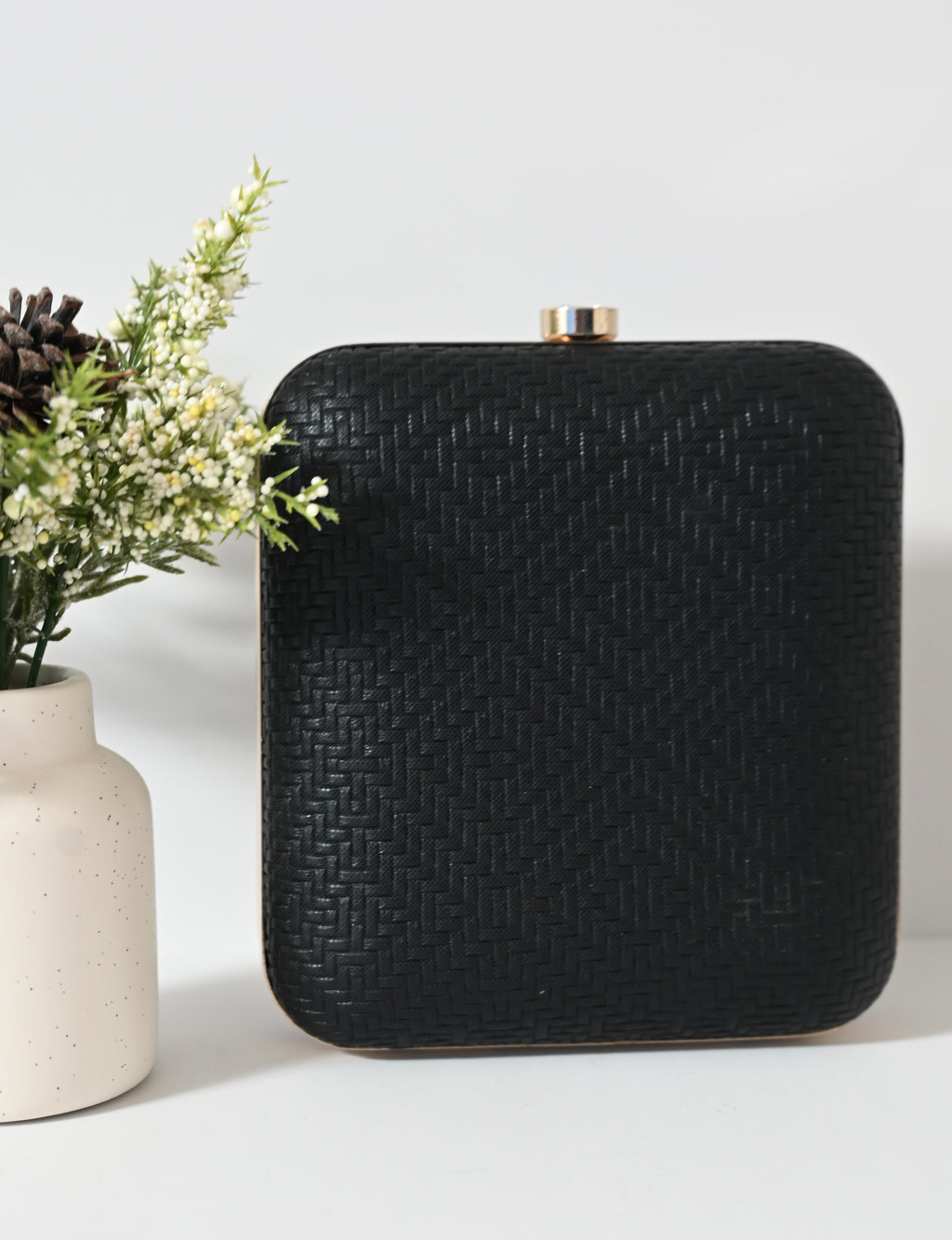 Geometric black evening purse with angular shell pattern and gold clasp