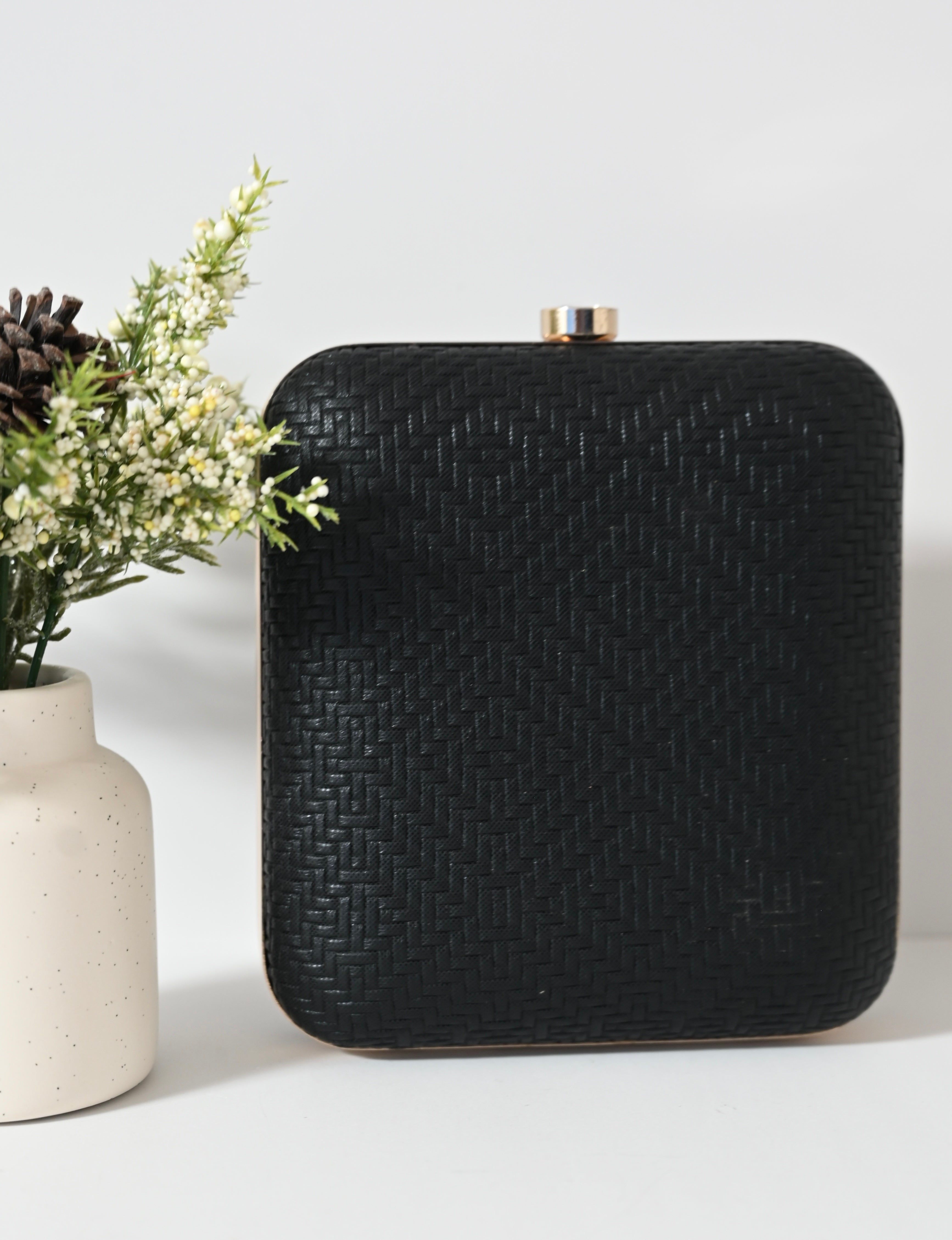 Geometric black evening purse with angular shell pattern and gold clasp