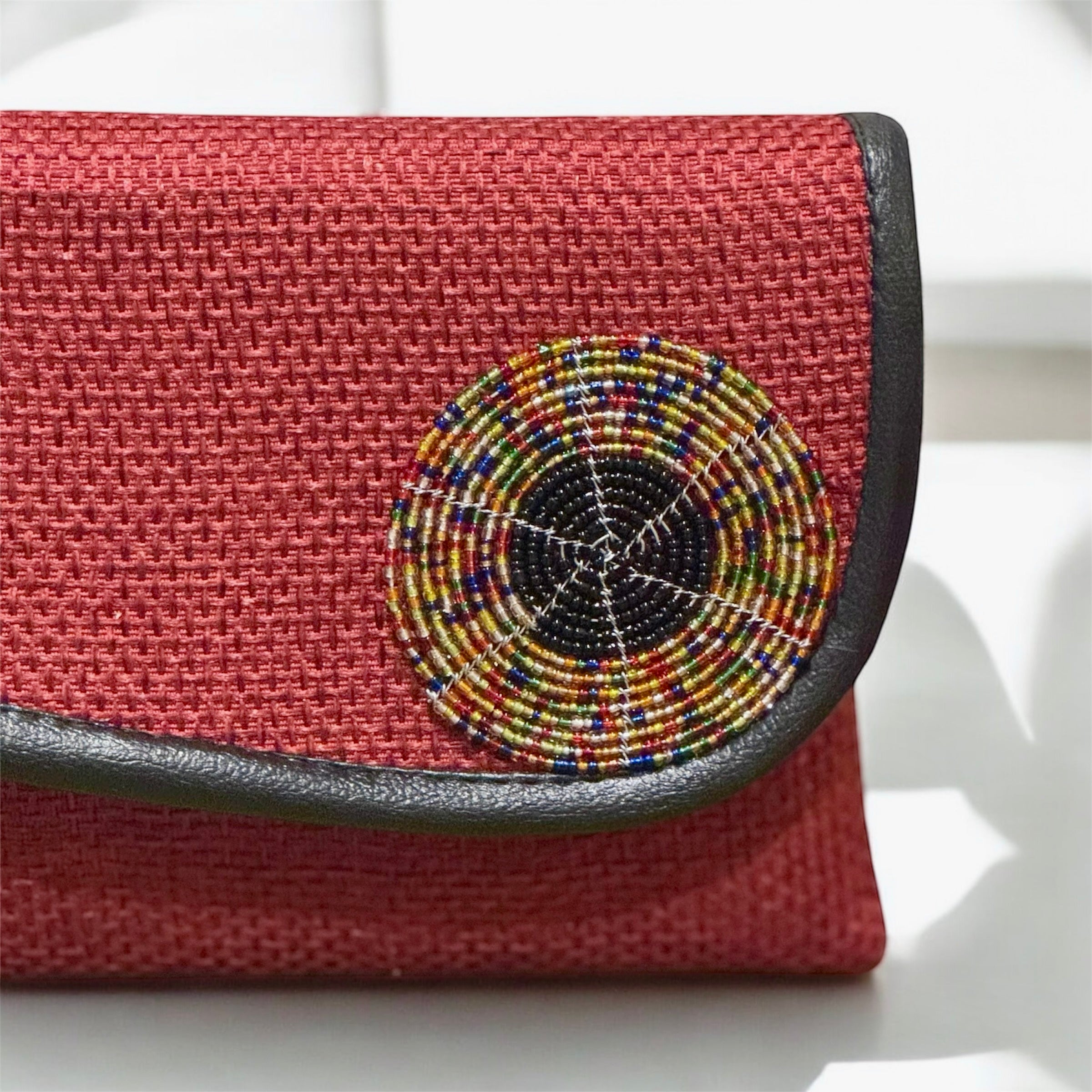 Burgundy evening clutch with rich textured surface and gold clasp hardware
