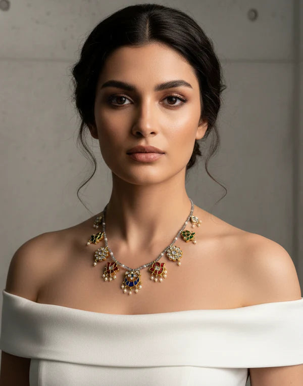 Woman wearing a detailed necklace against a neutral background