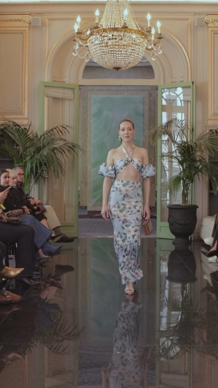 Woman wearing floral off-shoulder crop top and wide-leg skirt set walking in elegant chandelier ballroom – Indus Threads women's fashion collection